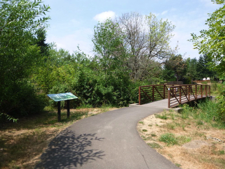Informational display as paved trail transitions to bridge